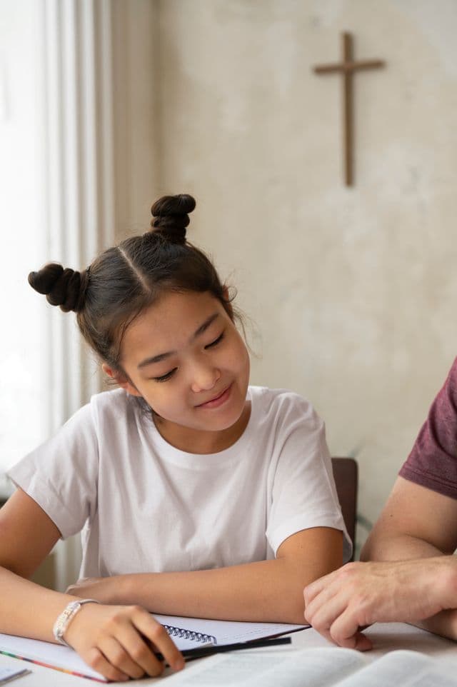 Smiling student studying with a tutor at home