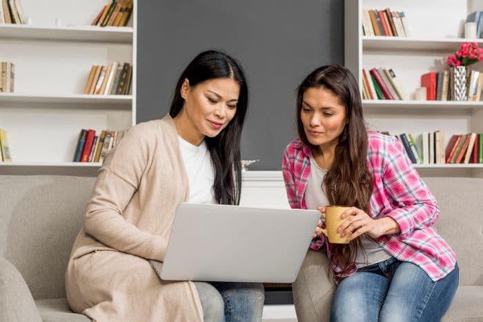 Parent and secondary school teenager going through maths work together at home