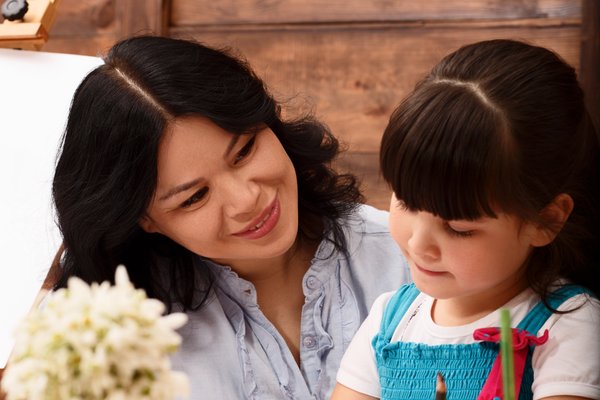 Parent helping primary school child with homework at home